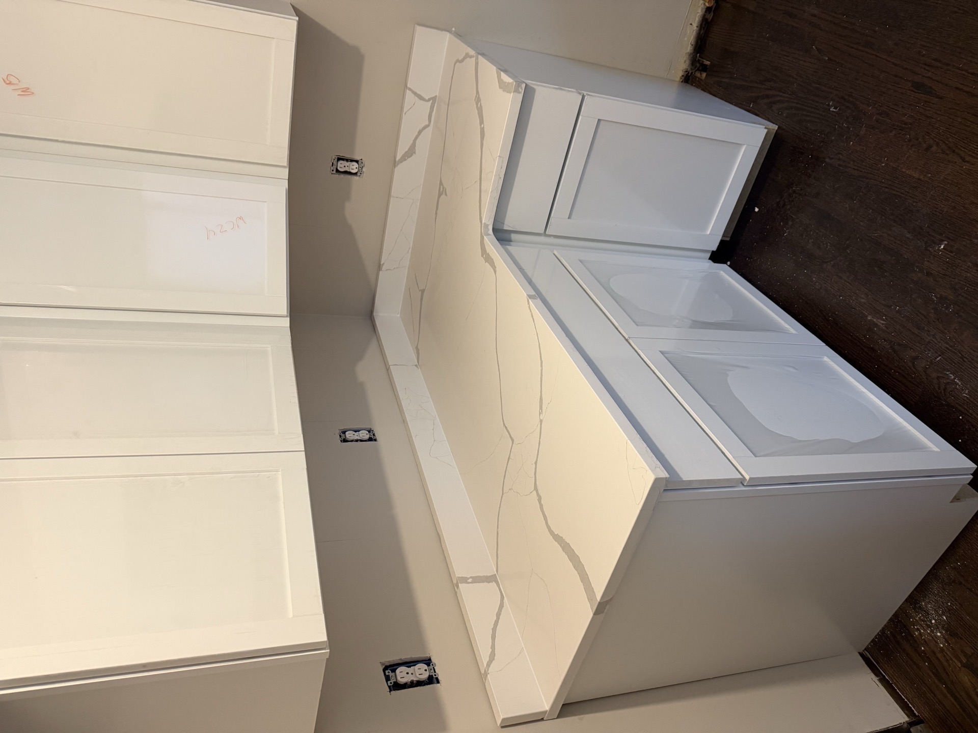 White stone corner countertop with subtle grey veining installed on white shaker cabinets