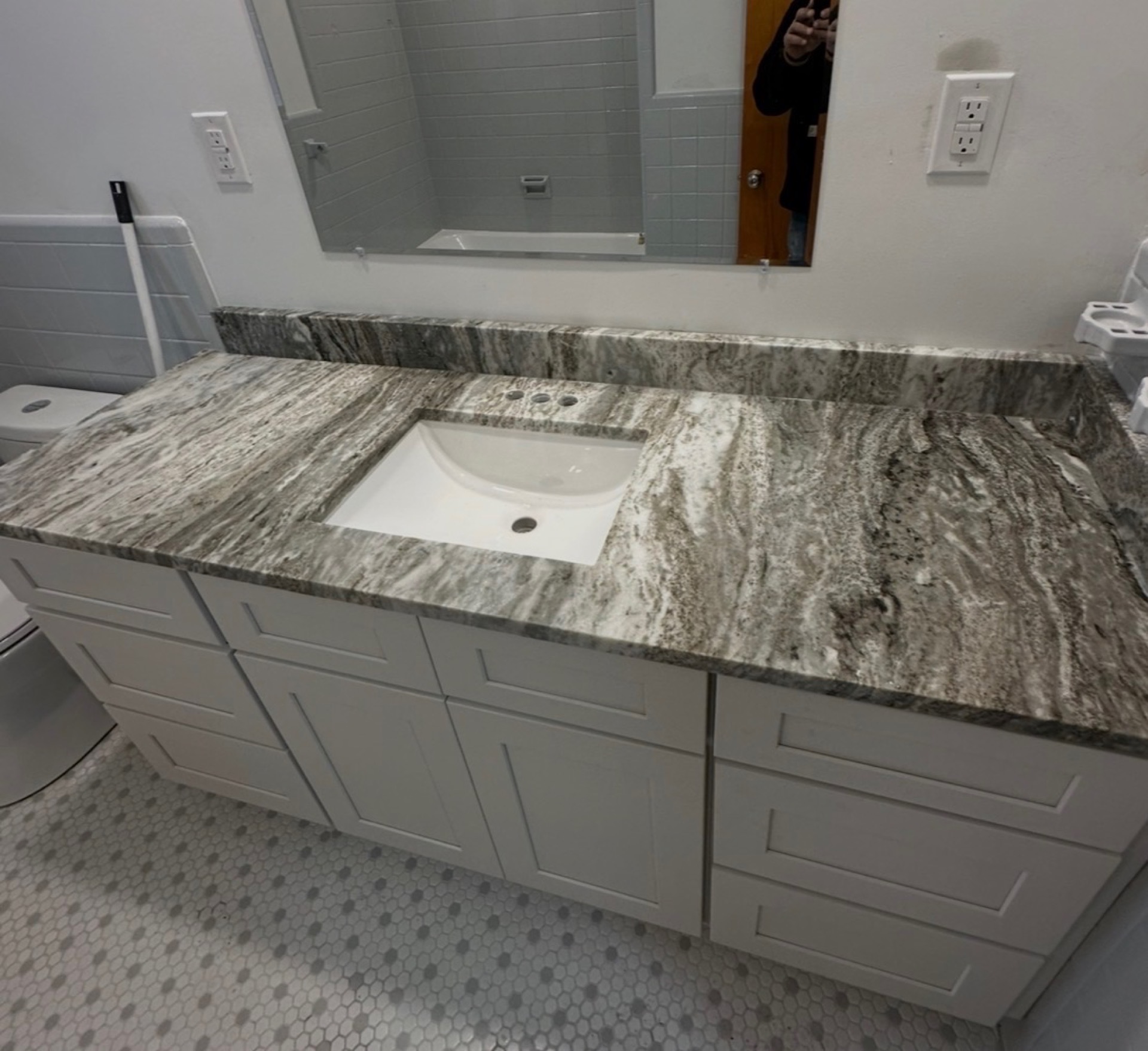 Bathroom vanity finished in dramatic grey and brown veined granite